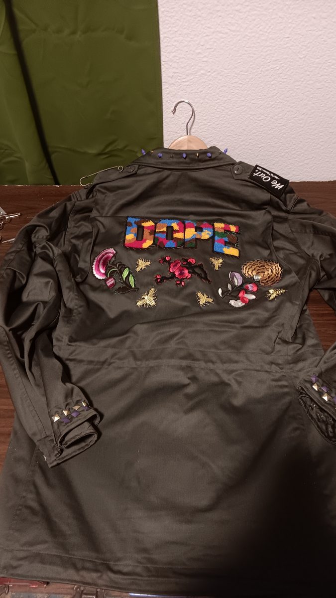 Activist Army jacket — back with HELLO lettering and floral patches